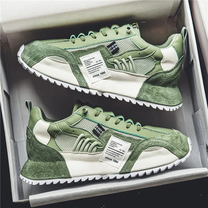 Pair of green and white casual sneakers with textured panels and white soles in a shoe box
