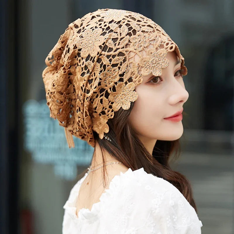 Woman wearing brown floral lace crochet headscarf and white embroidered blouse outdoors