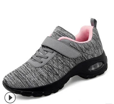 Gray and pink women's athletic sneaker with mesh upper, hook-and-loop strap, and cushioned sole