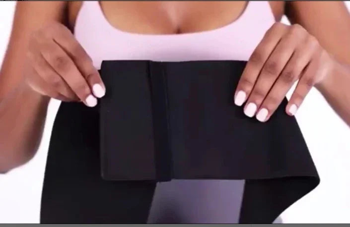 Woman wearing pink sports bra adjusting black waist trainer belt for fitness