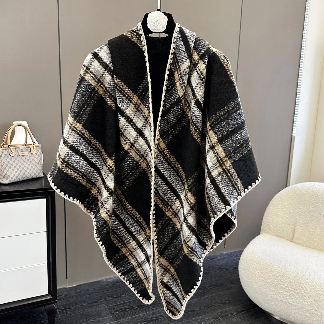 Black and beige plaid wool poncho hanging on a mannequin in a modern room