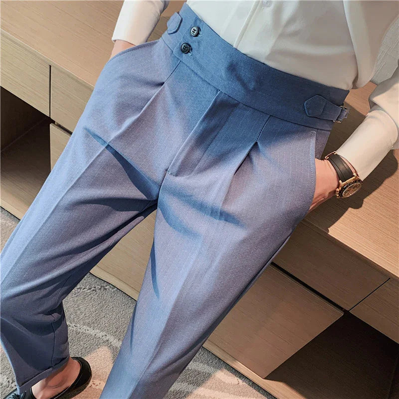 Close-up of man wearing light blue high-waisted dress trousers with pleats and side buckle detail