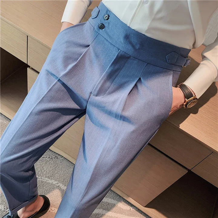 Close-up of man wearing light blue high-waisted dress trousers with pleats and side buckle detail