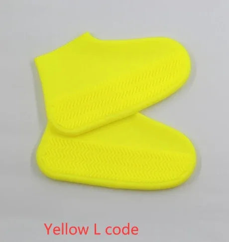 Bright yellow waterproof shoe covers with textured soles on a light background