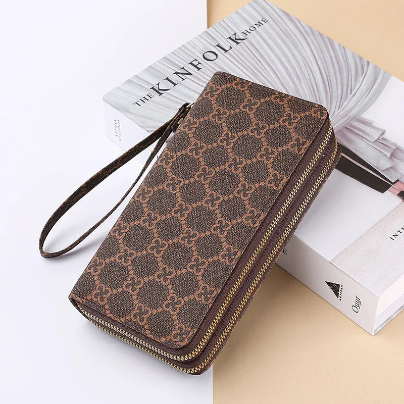 Brown patterned zip-around wristlet wallet on a Kinfolk Home book