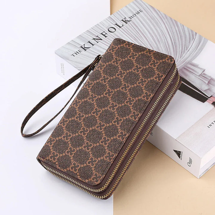 Brown patterned zip-around wristlet wallet on a Kinfolk Home book