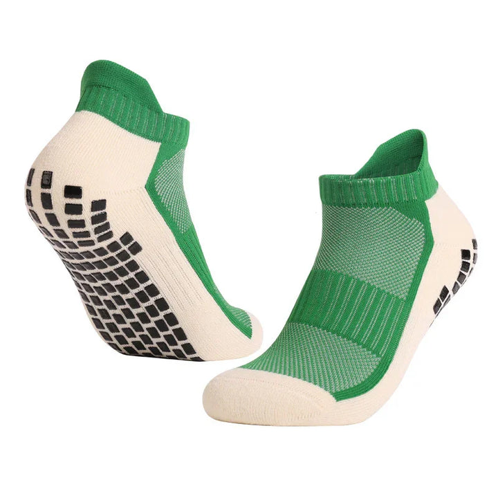 Green and beige low-cut grip socks with black anti-slip soles for athletic use