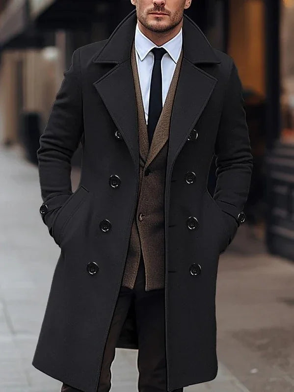 Man wearing stylish black double-breasted coat over brown vest and white shirt with black tie on city street