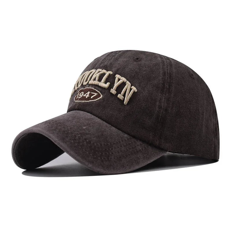 black baseball cap with embroidered text 'BROOKLYN 1947' in beige thread