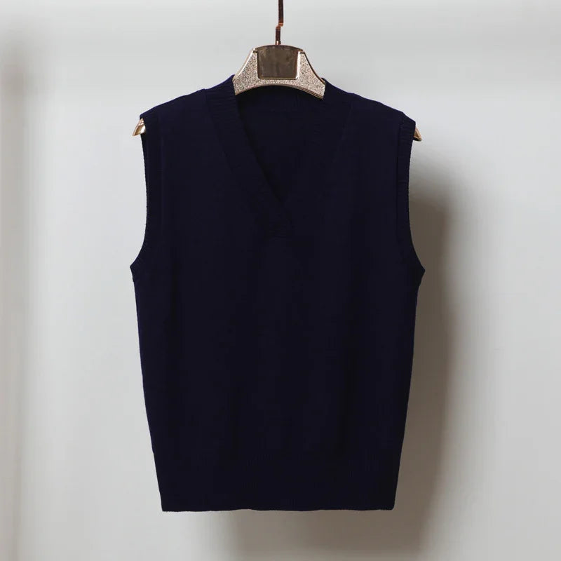 Navy blue sleeveless V-neck sweater vest on wooden hanger against white background