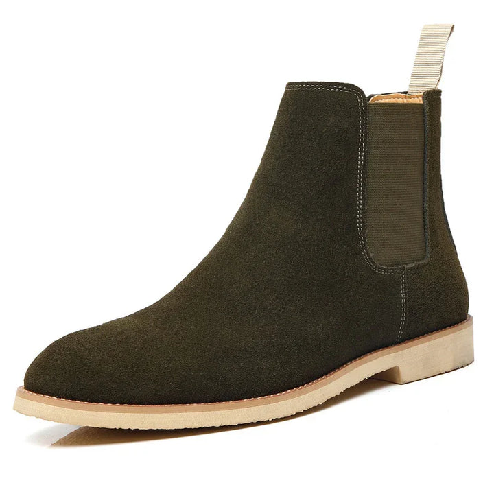 Olive green suede Chelsea boot with light beige pull tab and sole on white background