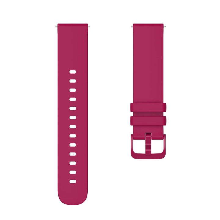 Pink silicone watch band with buckle and adjustment holes isolated on white background