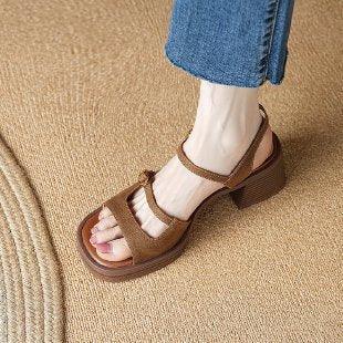 Brown suede open-toe block heel sandal worn with blue cropped jeans on woven rug