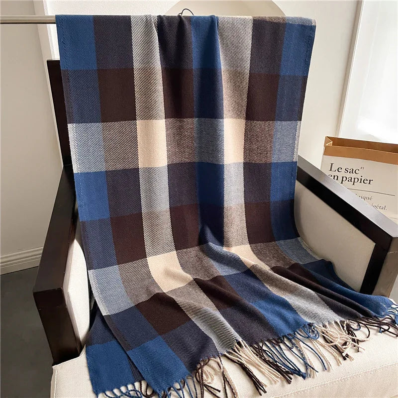 Blue, brown, and cream checkered wool throw blanket with fringes on beige armchair