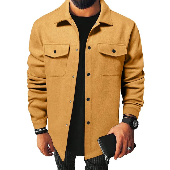 man wearing camel brown button-up jacket with chest pockets holding black wallet