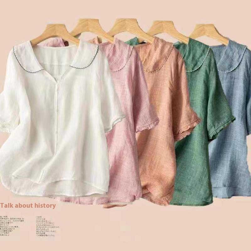 Five lightweight linen blouses in white, pink, peach, green, and blue with scalloped collars on wooden hangers