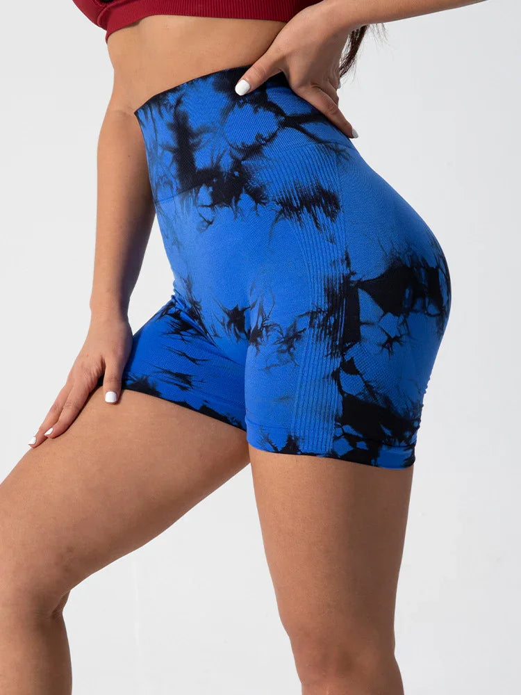 Woman wearing high-waisted blue and black tie-dye athletic shorts with ribbed detailing