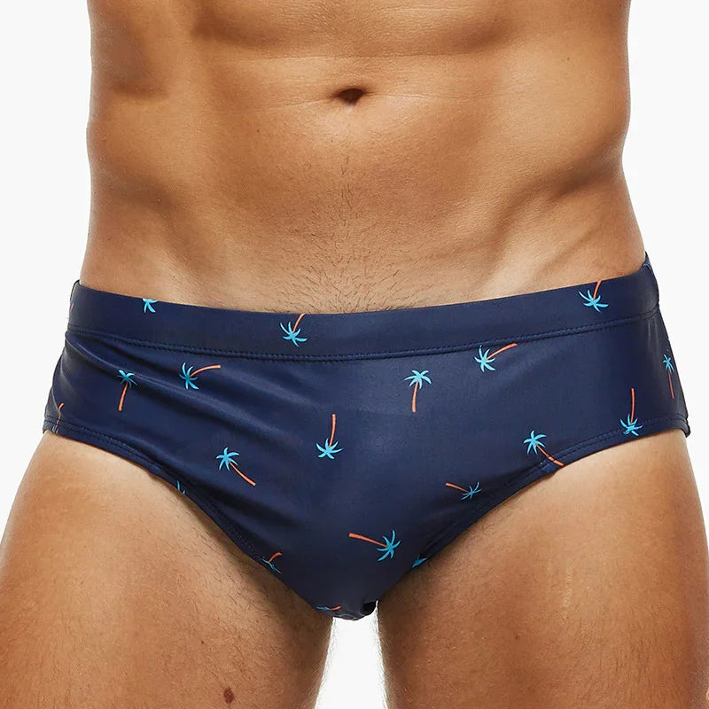 Close-up of man wearing navy blue swim briefs with small palm tree print