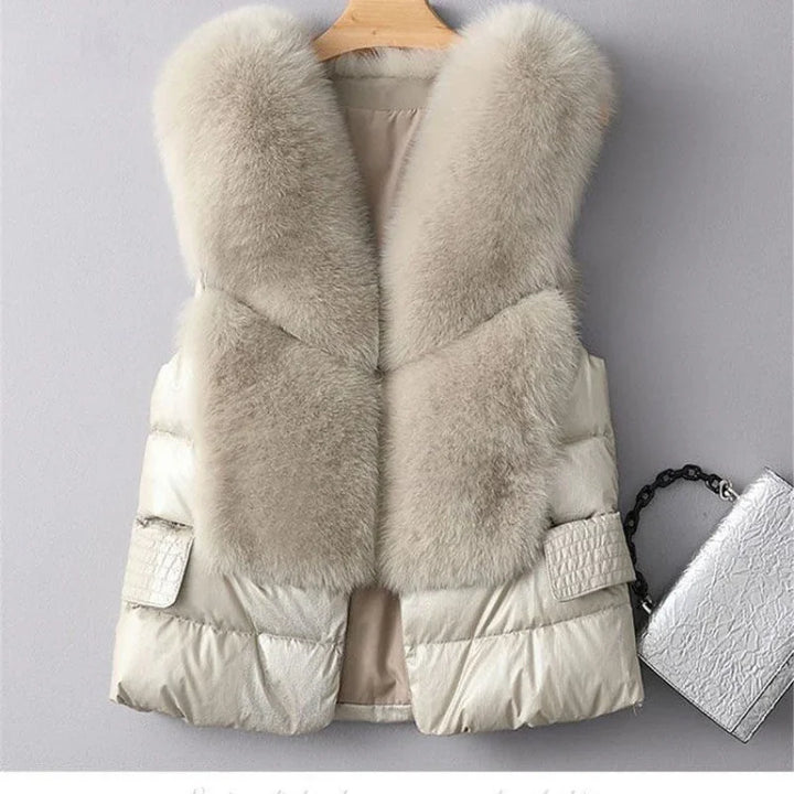 Cream-colored sleeveless puffer vest with large plush fur collar and side pockets, displayed on hanger