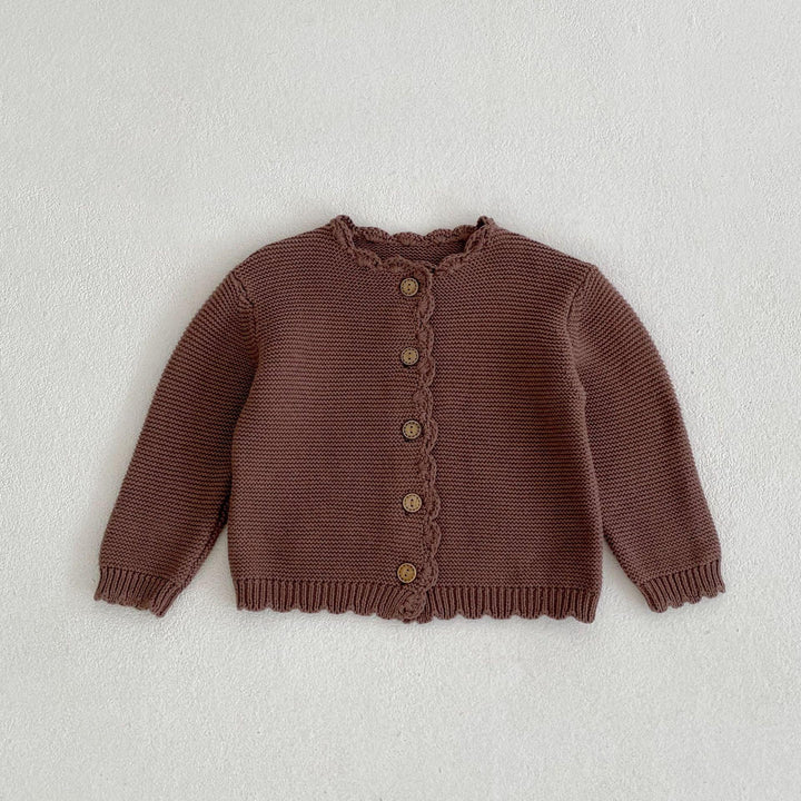 Brown knitted baby cardigan with wooden buttons and scalloped edges laid flat on white background
