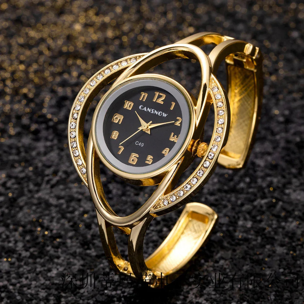 Elegant gold women’s wristwatch with black dial and rhinestone-studded open band on black glitter background