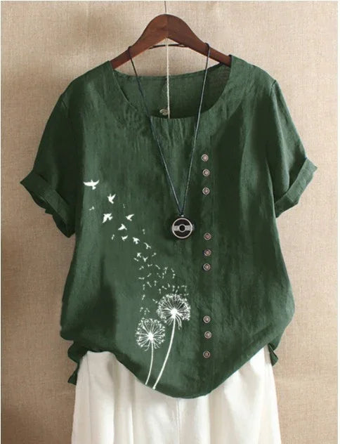 Green linen short sleeve blouse with white dandelion and flying birds print, button details, and necklace