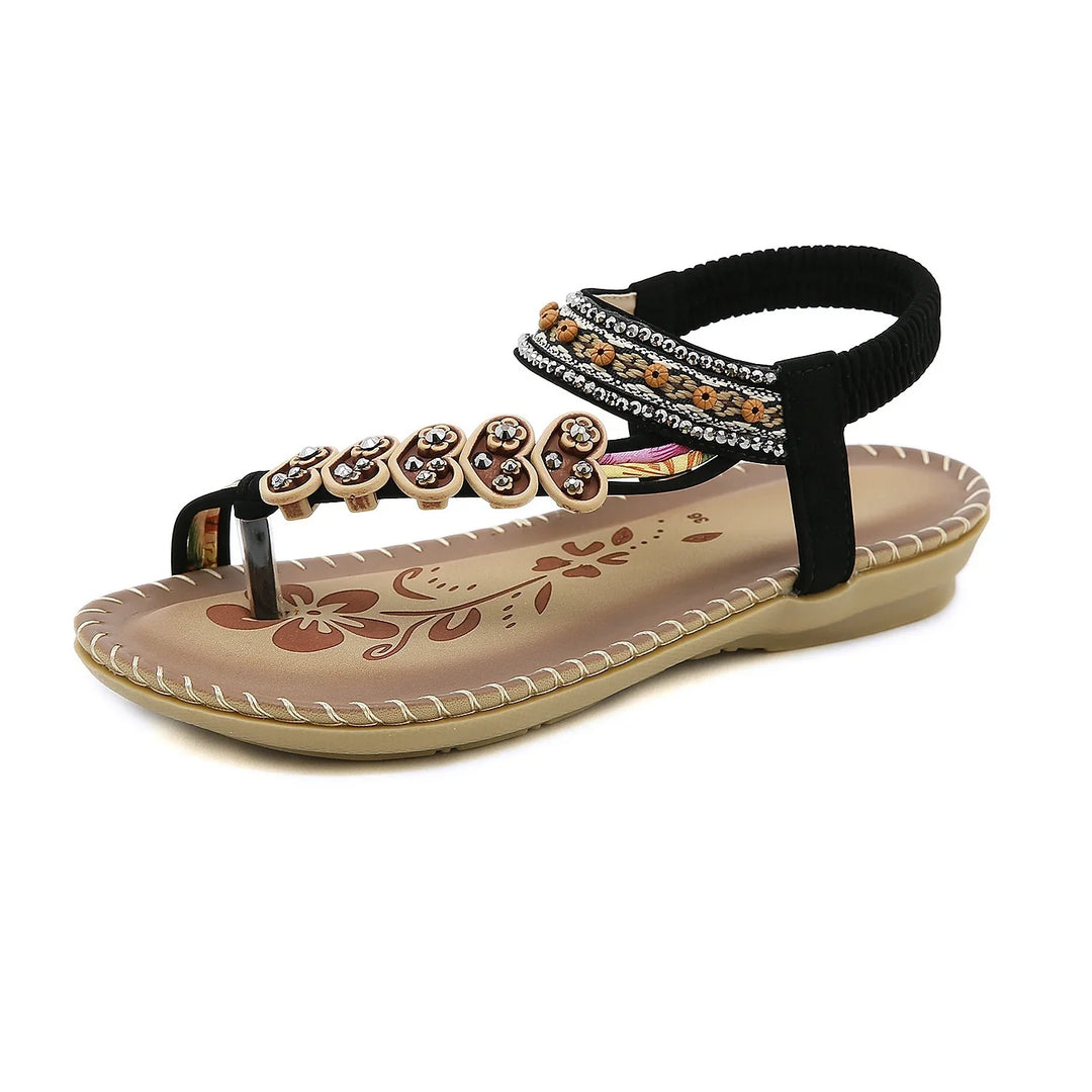 brown and black women's sandal with floral print footbed and decorative straps