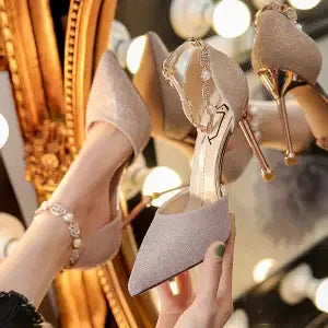 Sparkling high heel shoes with ankle straps and rhinestones in front of vintage mirror and vanity lights