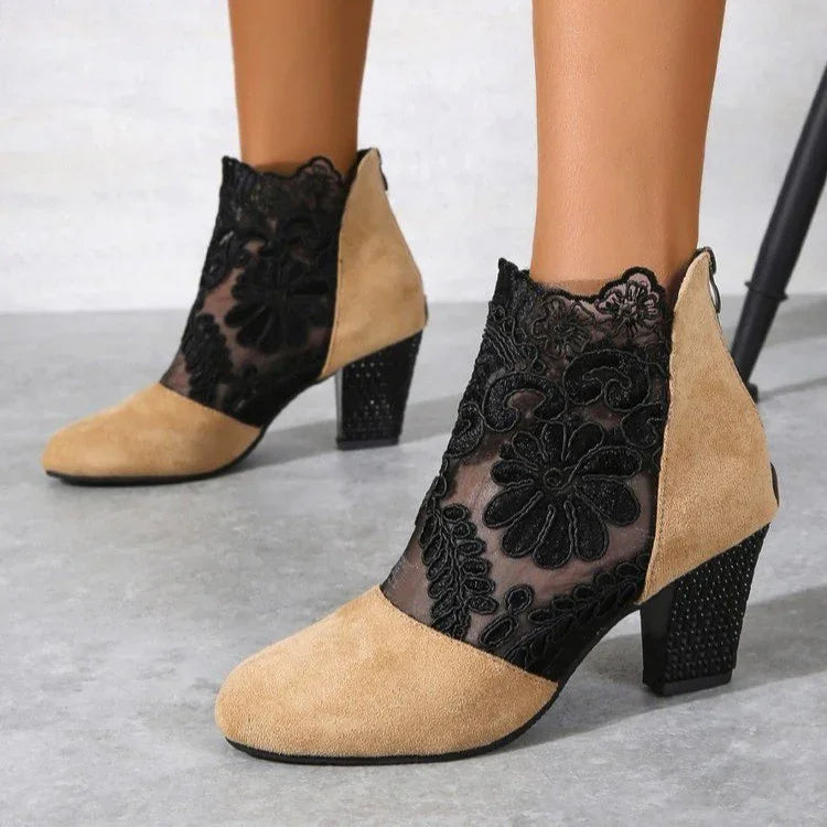 Beige suede and black floral lace mesh ankle boots with block heels on gray floor