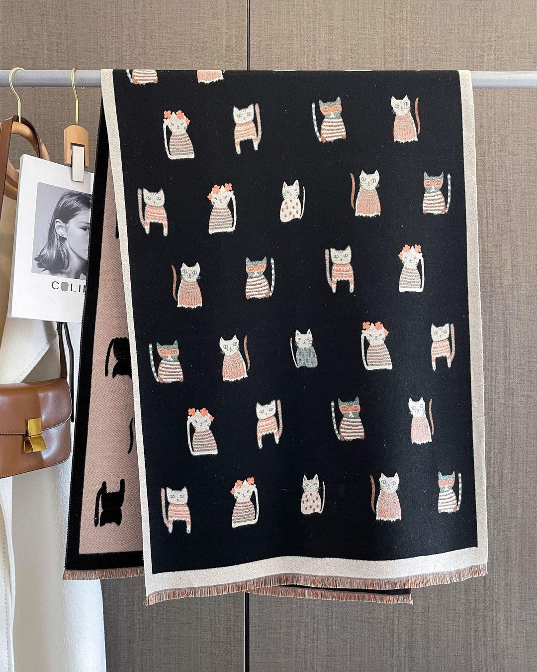 Black scarf hanging with cute cat illustrations in pink, white, and gray patterns