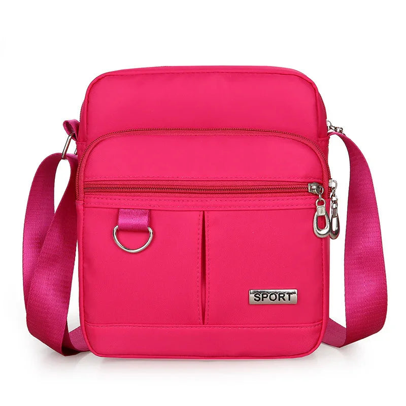 Bright pink sport crossbody bag with adjustable strap, front zipper pocket, and metal detail
