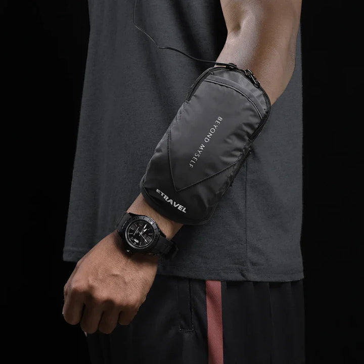 Black Etravel arm pouch worn on forearm, black shirt, and watch on wrist