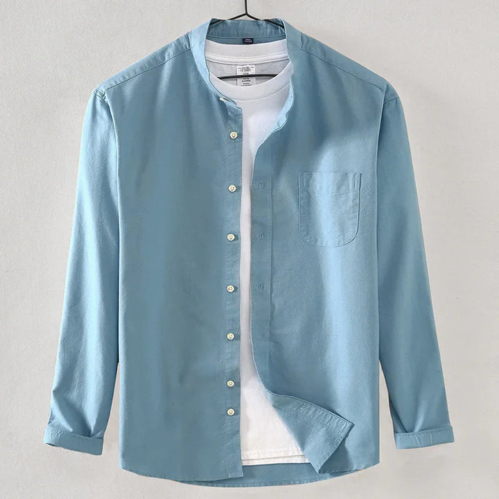 Light blue long sleeve casual shirt with Mandarin collar over a white t-shirt on hanger