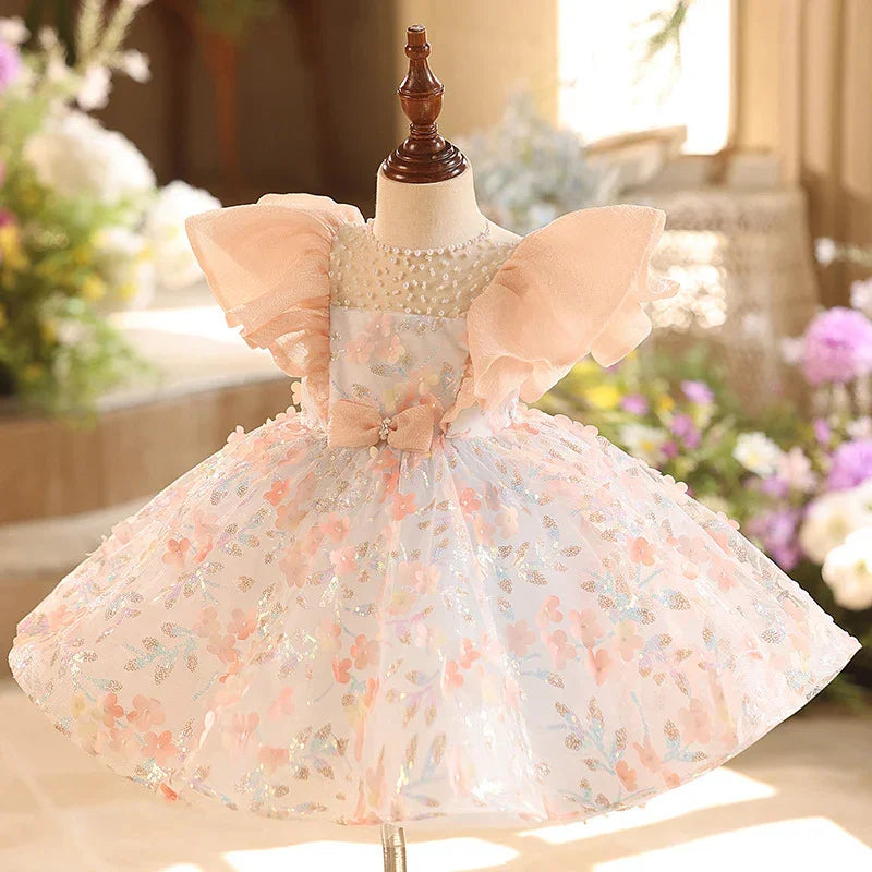 Elegant baby girl dress with puff sleeves, pearl neckline, pink floral tulle skirt, and bow detail