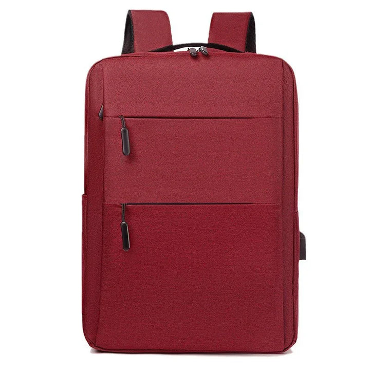 Red rectangular backpack with two front zippered pockets and padded shoulder straps on white background
