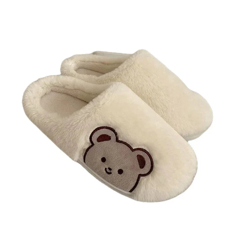 Cozy beige plush slippers with a cute embroidered bear face on the front, ideal for indoor wear