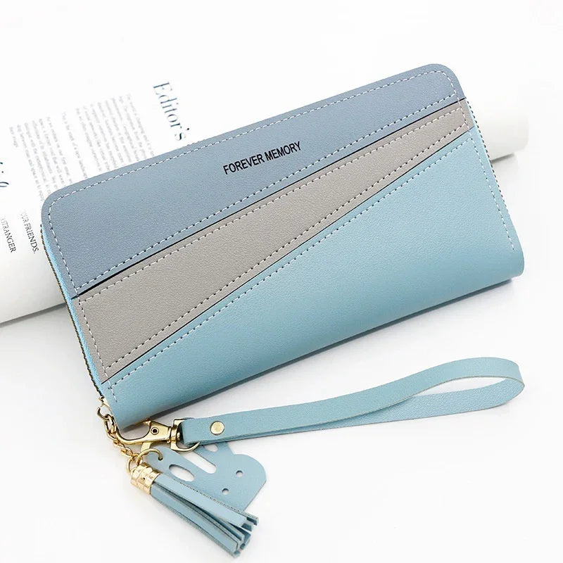 blue and gray color block wristlet wallet with "FOREVER MEMORY" text and tassel charm on white background