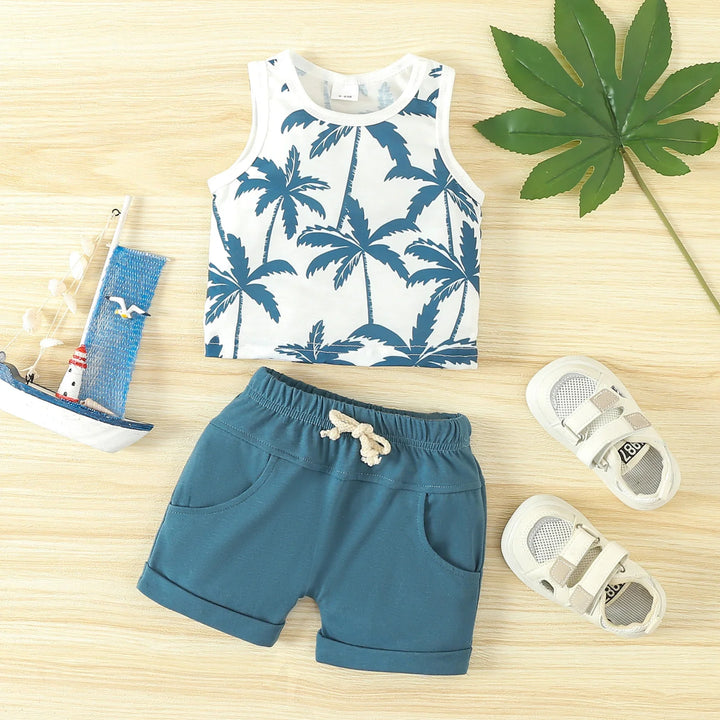 Toddler summer outfit with palm tree print tank top, blue shorts, white sandals and toy sailboat