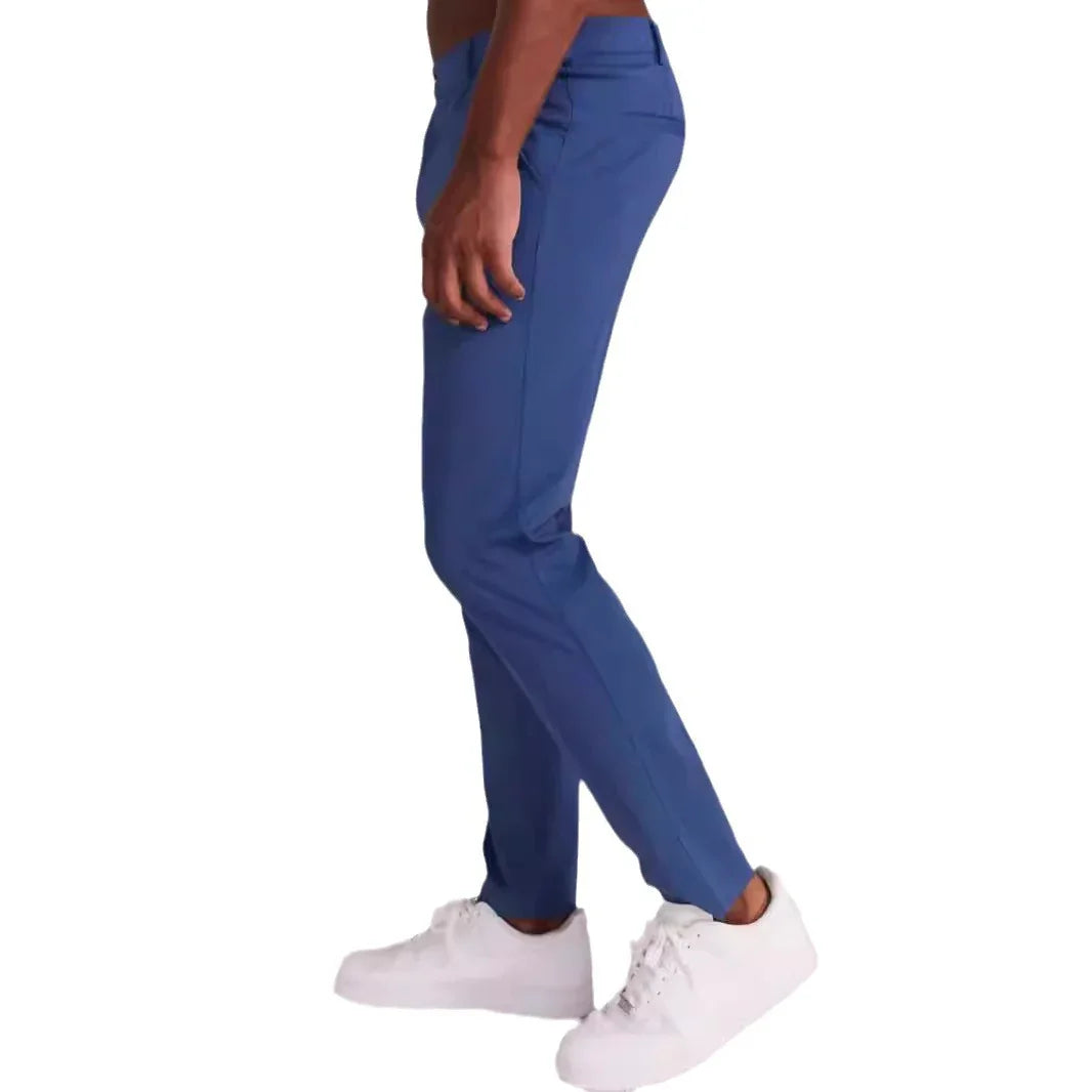 Side view of person wearing slim fit blue pants and white sneakers on white background