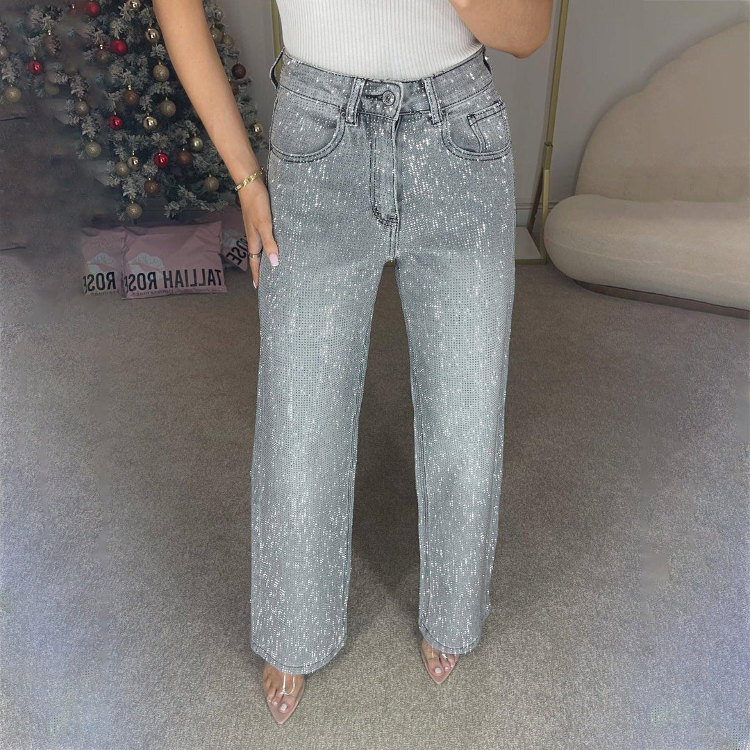 Woman wearing high-waisted silver sequin wide-leg jeans with clear strap heels in modern room