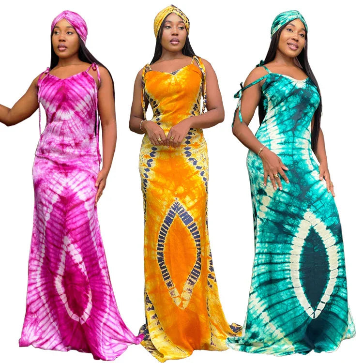 Women wearing vibrant tie-dye maxi dresses in pink, yellow, and teal with matching head wraps