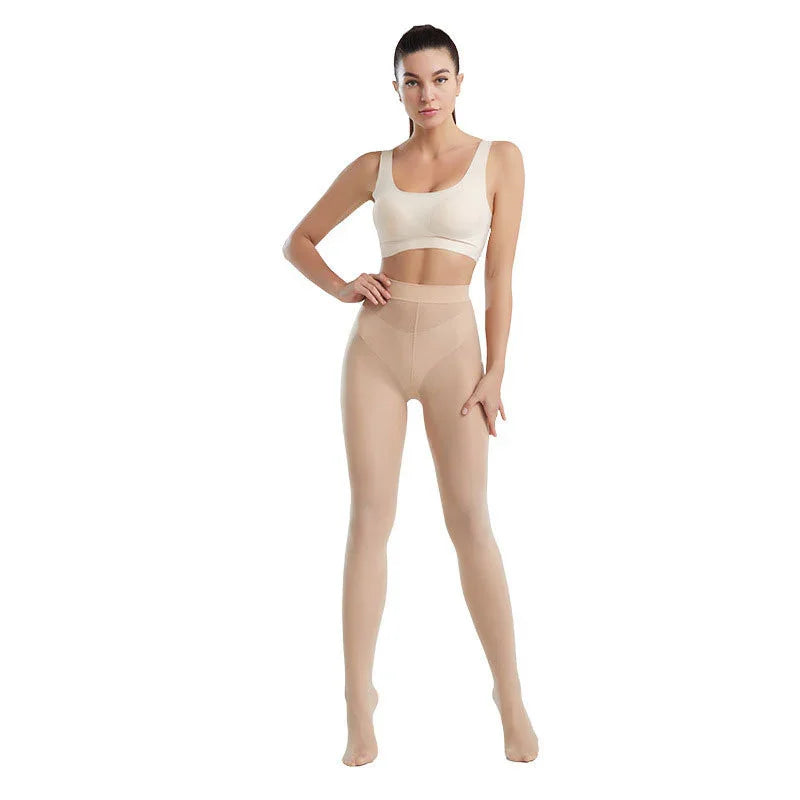 Woman wearing beige high-waisted sheer shapewear tights and cream sports bra on white background