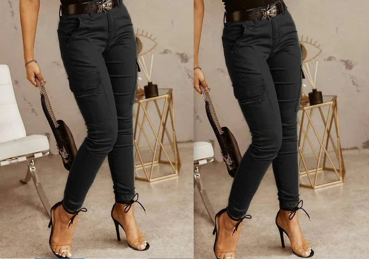 Woman wearing fitted black cargo pants and clear high-heeled sandals in minimalist room