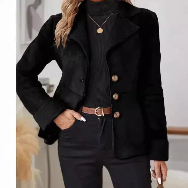 Woman wearing black buttoned jacket over black turtleneck top with brown belt and black pants