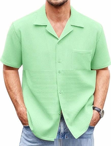 Man wearing light green textured short-sleeve button-up shirt with pocket and blue jeans
