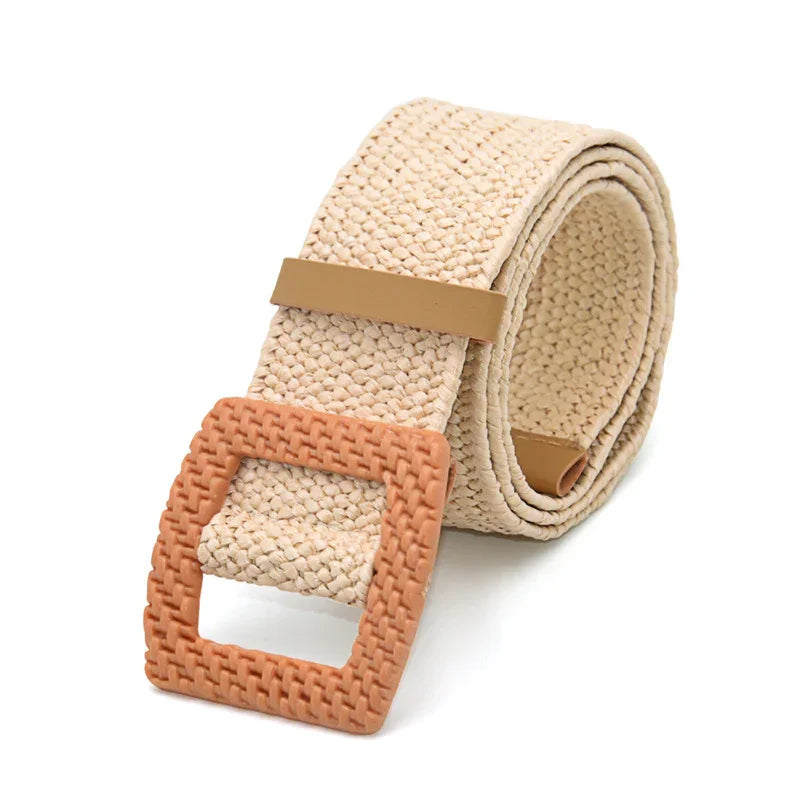 Beige woven fabric belt with textured square tan buckle rolled on white background