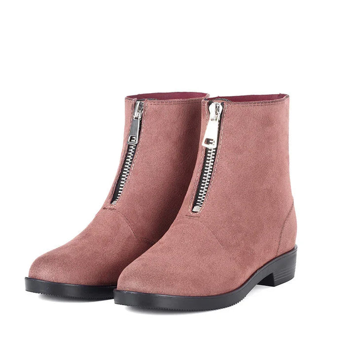 Pair of rose pink suede ankle boots with front silver zippers and black soles