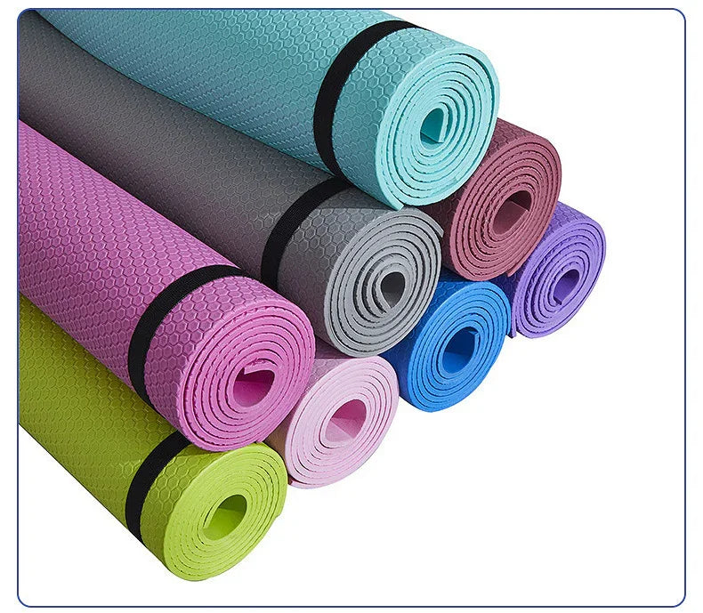 Colorful rolled yoga mats with textured surface and black straps, fitness accessories