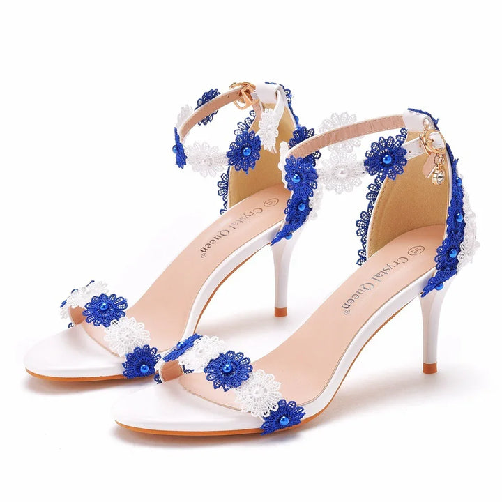 White high heel sandals adorned with blue and white floral lace and blue bead embellishments