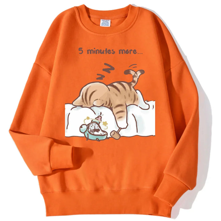 Orange sweatshirt featuring cartoon cat sleeping on bed with alarm clock and text '5 minutes more'